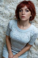 In this Candy AI Una Tierney portrait, the AI generated character sits on a soft white rug wearing a fitted grey top in a cozy indoor setting.